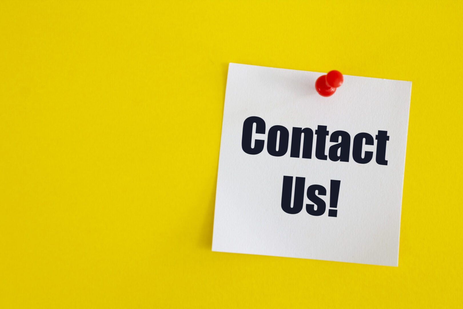 Contact us, written on an adhesive note on a yellow background.